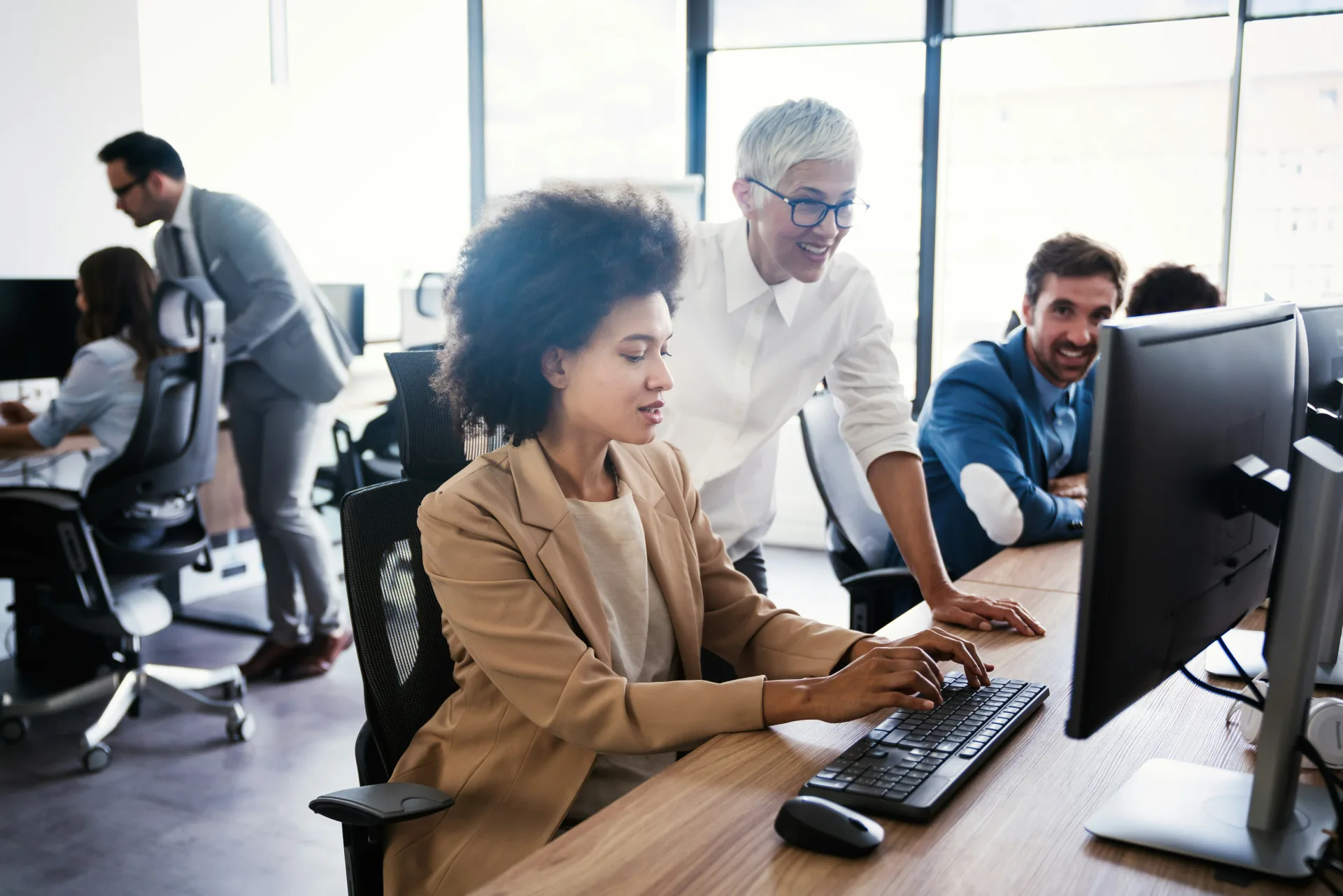 A collaborative team working at connected office workstations