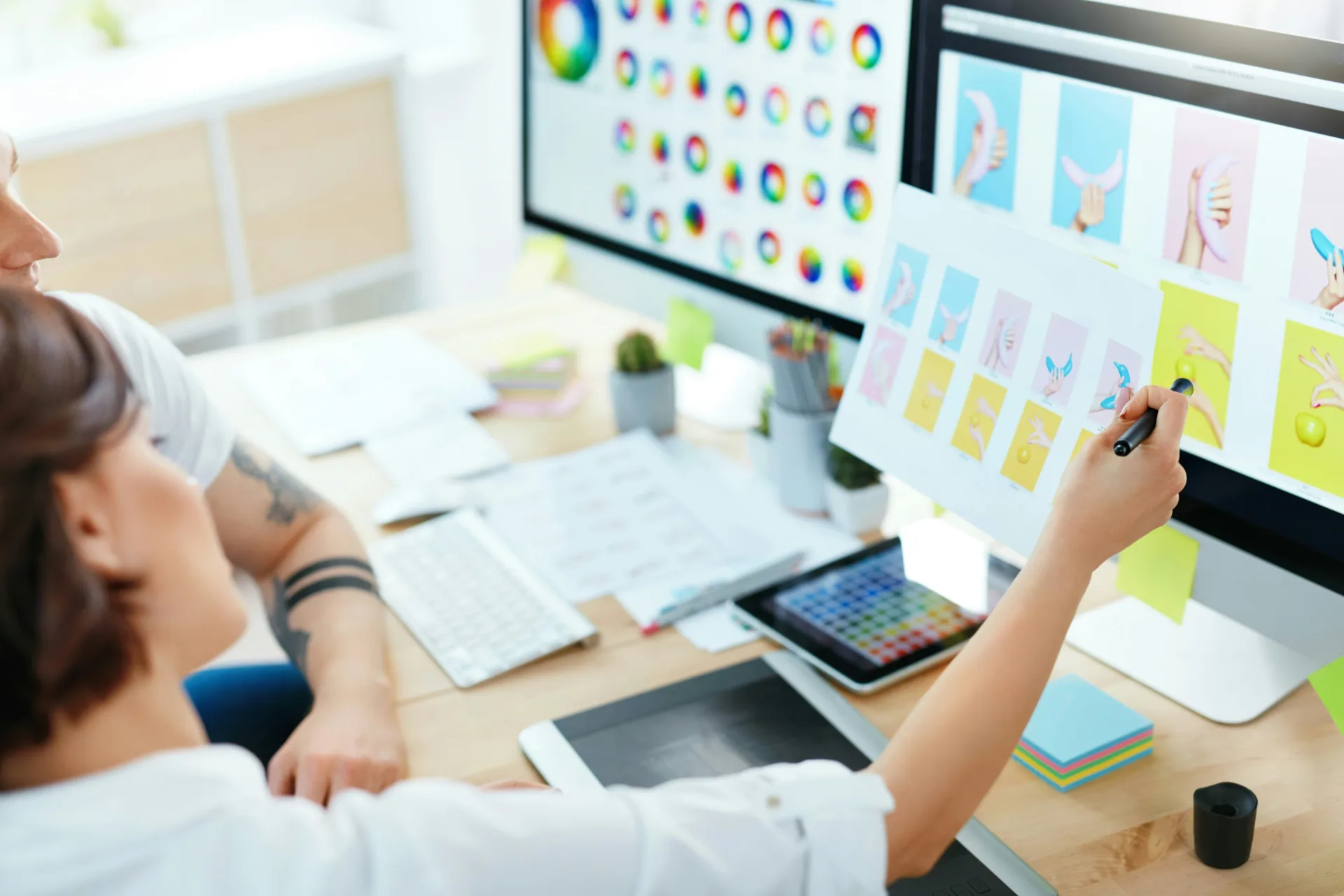 Designers reviewing a website interface at a workstation